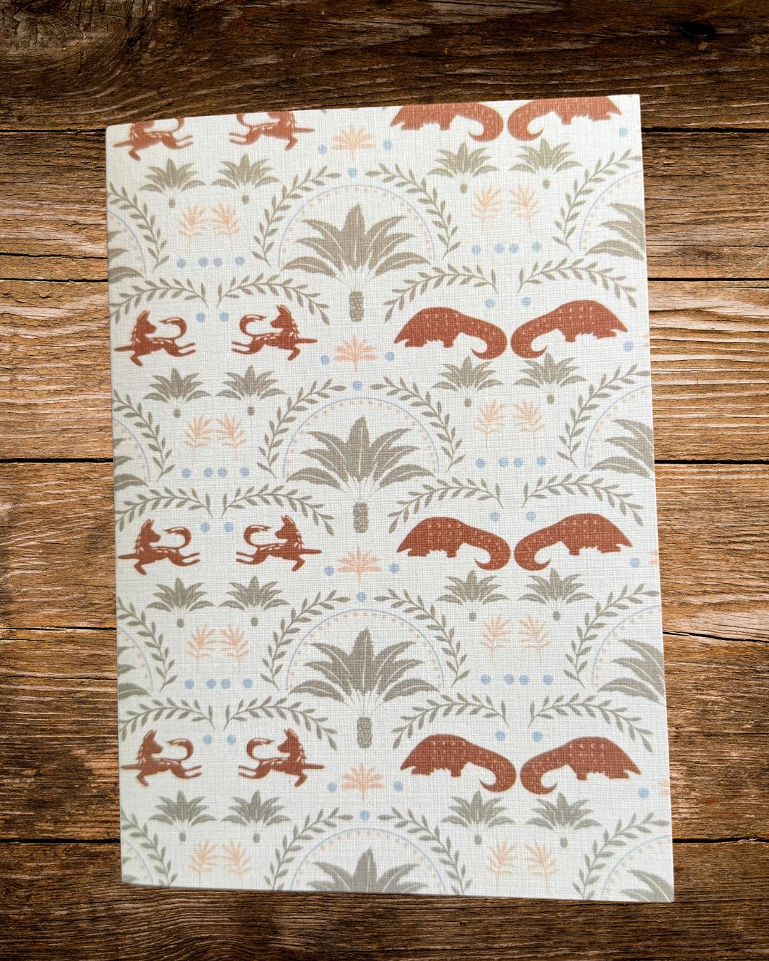 the arch card, sage and terracotta arches of cycads, pangolins and wild dogs