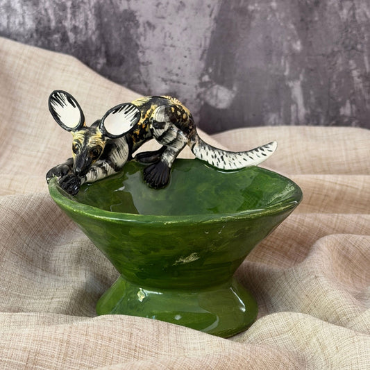 forest green ceramic mini raised bowl with a hand painted african wild dog stretched across the rim, handmade in south africa