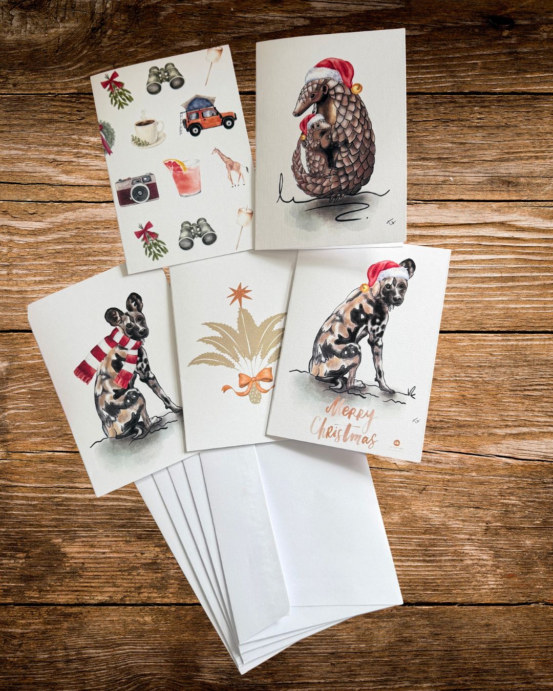 set of five african wildlife christmas cards with envelopes on a wooden table