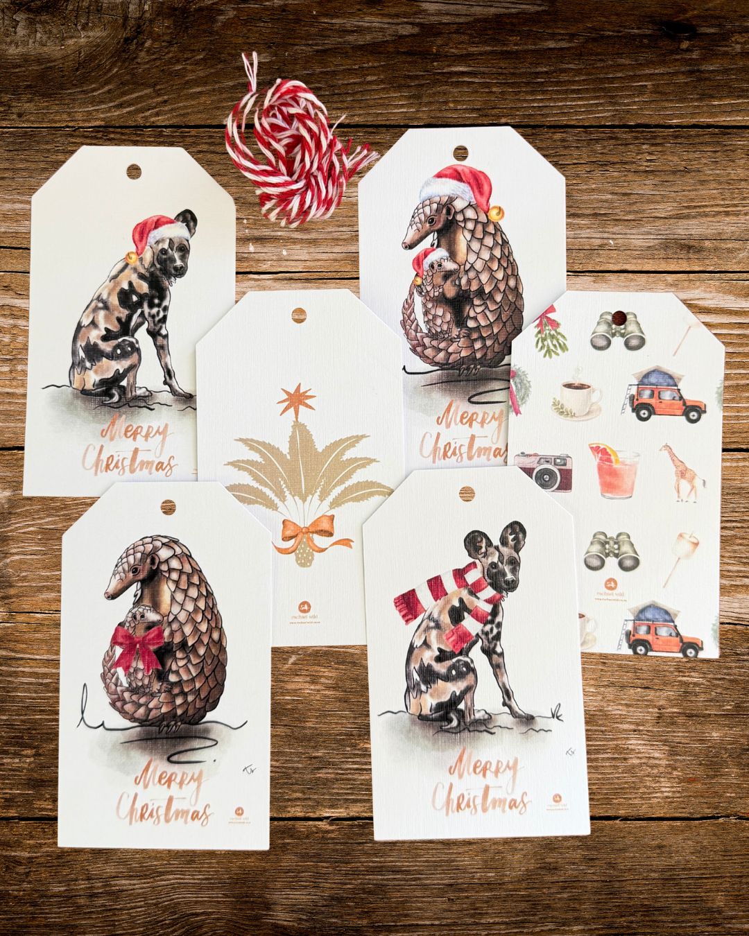 six african wildlife christmas gift tags on a wooden table